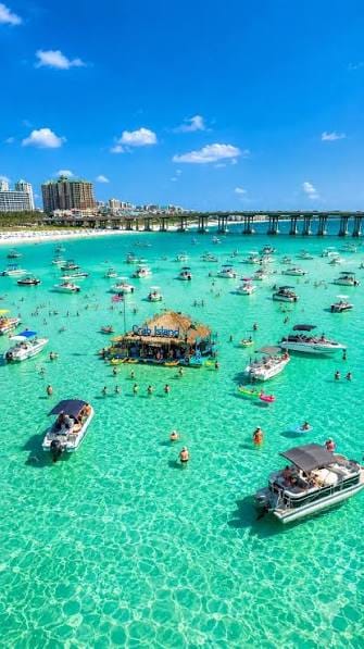 Boats surround a floating bar in turquoise water